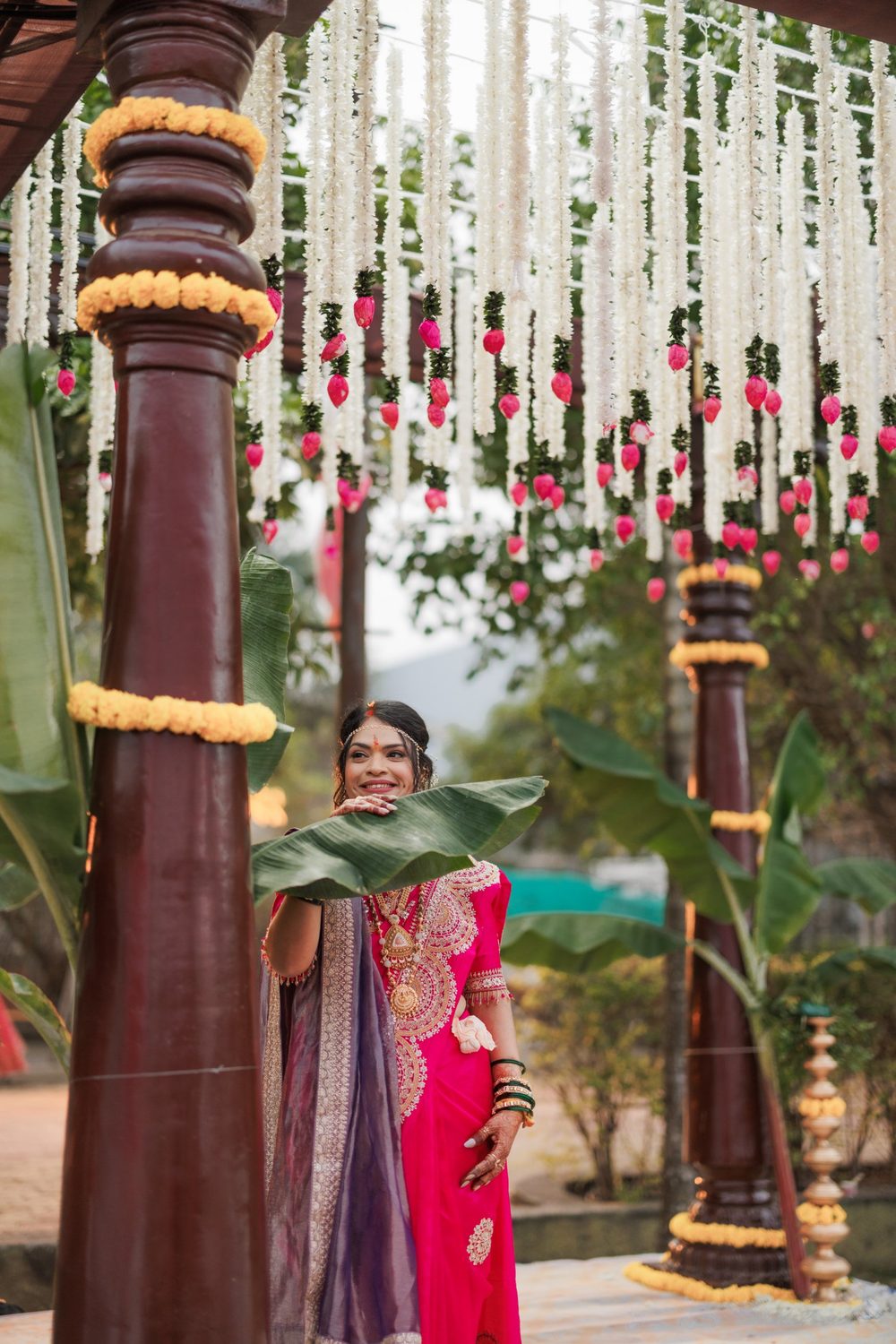 Bride under hanging white flower garlands
